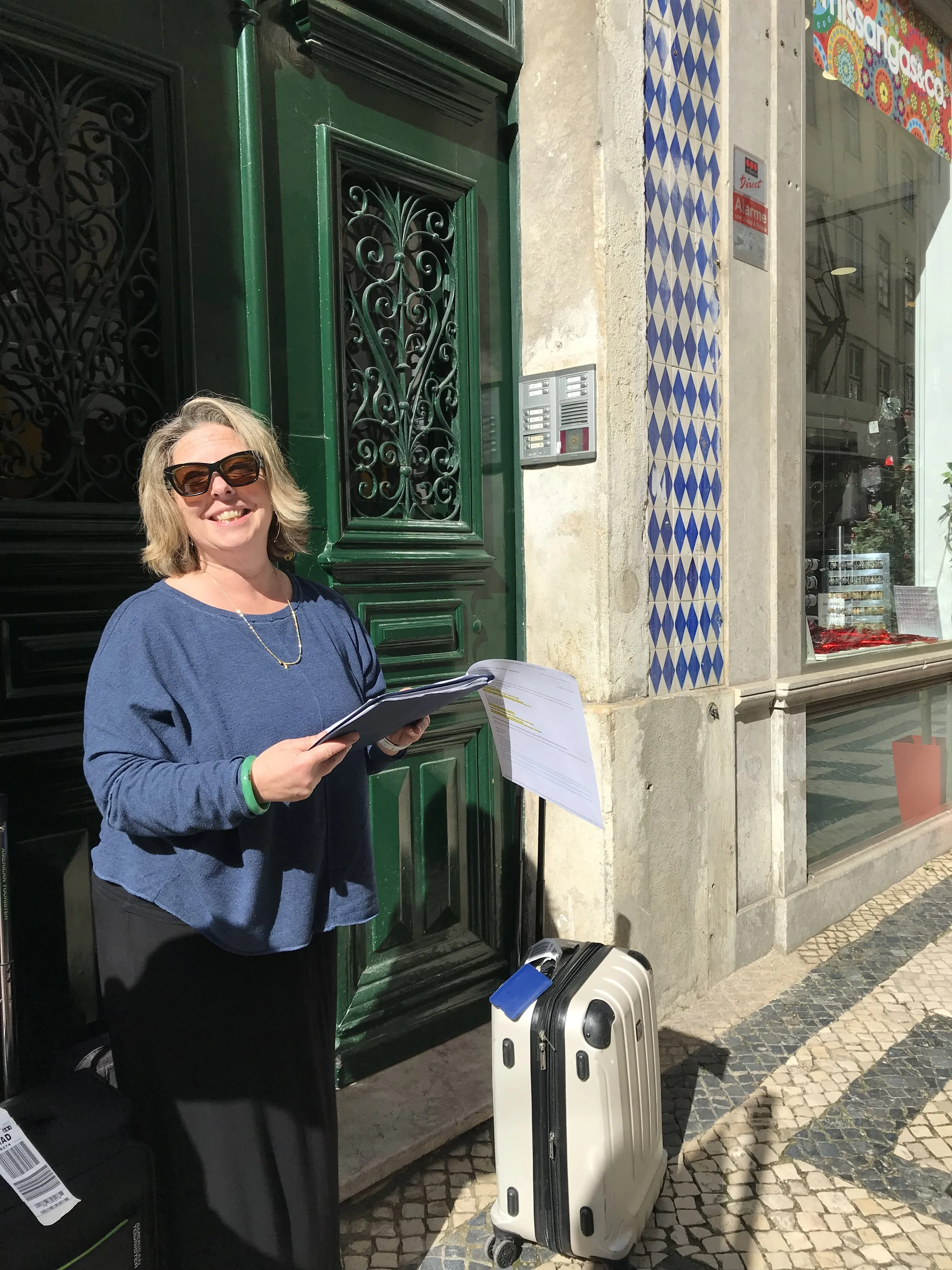 Jodie standing outside a building in Lisbon with a suitcase